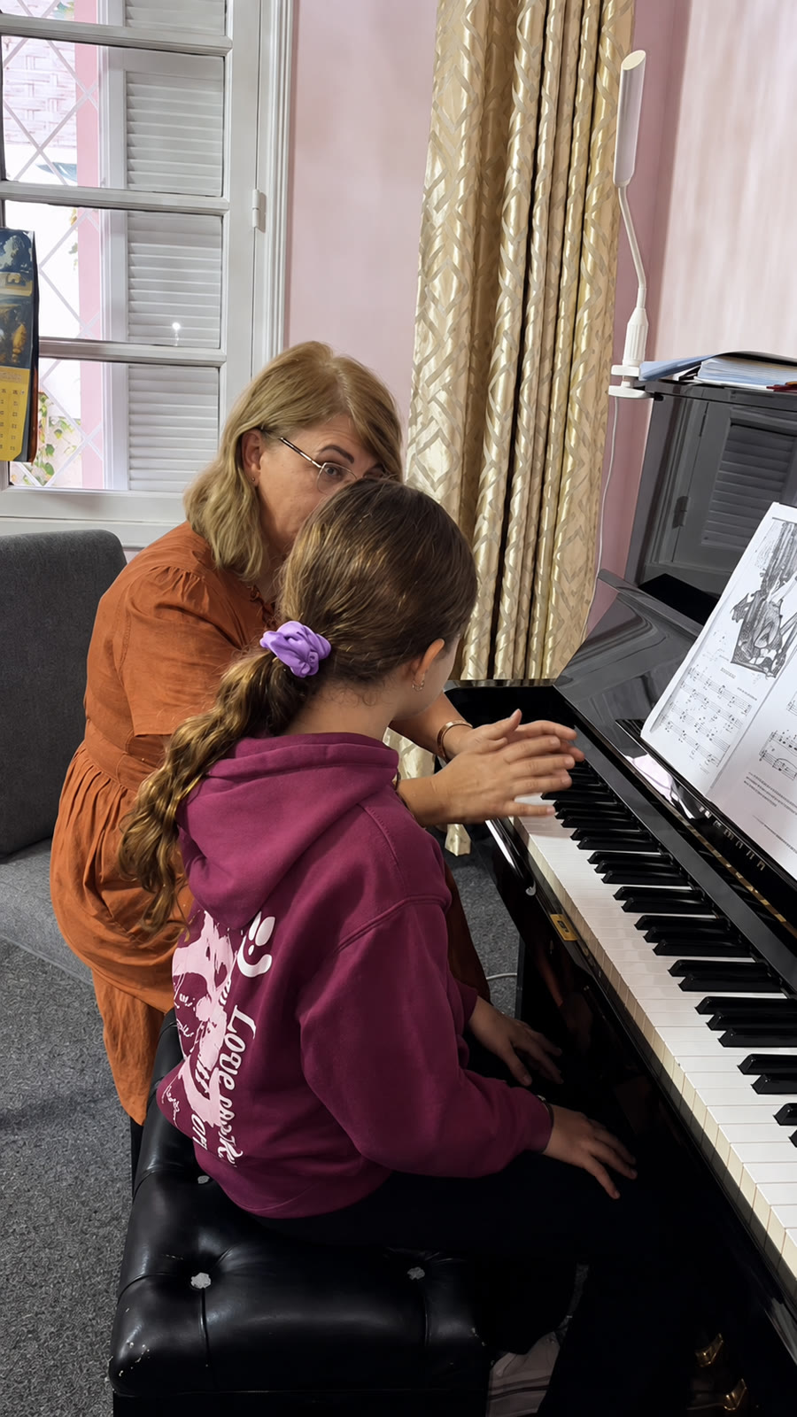 Professeure guidant une jeune élève au piano